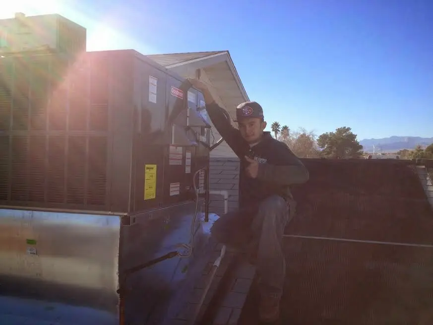 HVAC technician performing HVAC Inspection on a rooftop unit in Wright
